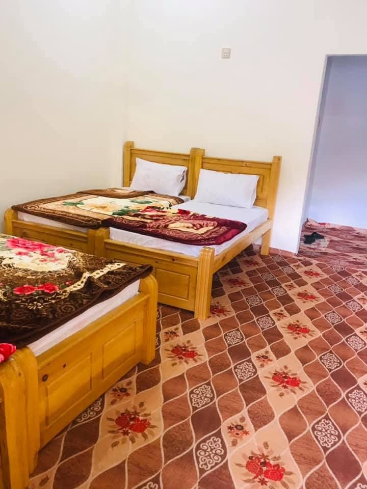 Room with wooden triple bed setup